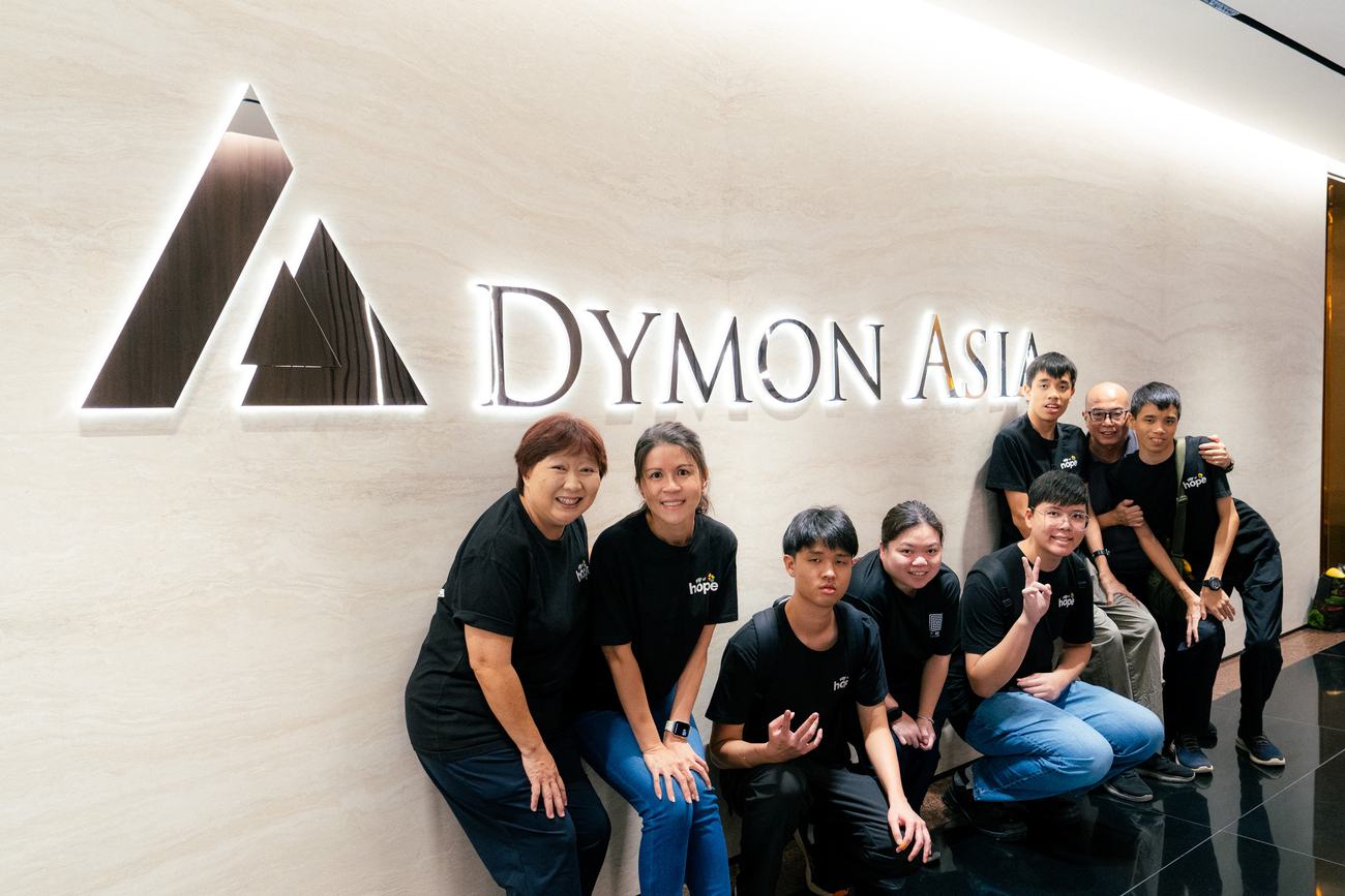 KTM youths and the Dymon Asia team at the Dymon Asia sign