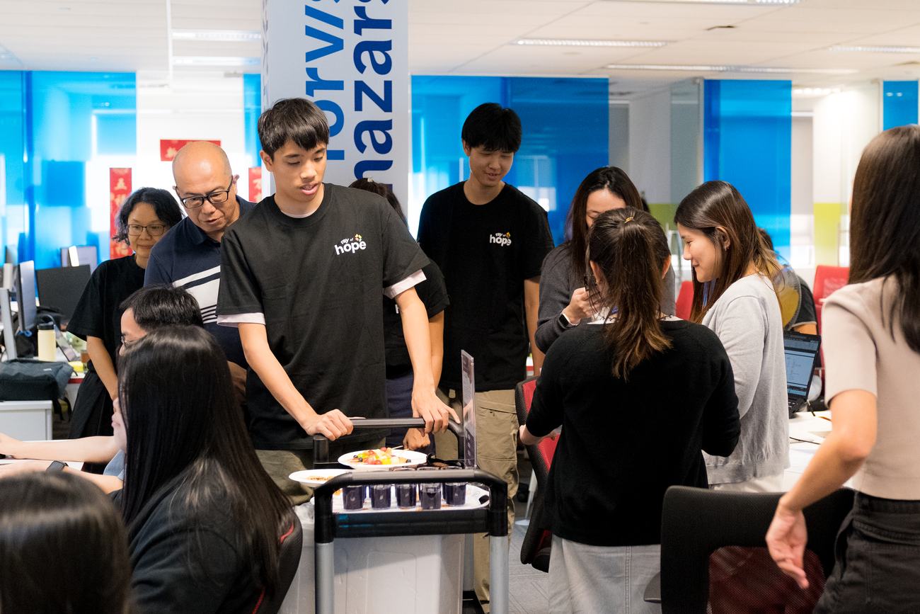 A youth serving colleagues from a cart